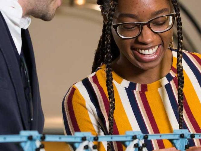 Woman is smiling looking down at her project